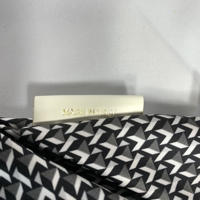 Der geometrische Mini-Seesack von ROBERTA PIERI in Schwarz-Weiß mit weißem Etikett mit der Aufschrift "MADE IN ITALY" in goldenen Buchstaben. Der Hintergrund ist schlicht weiß.