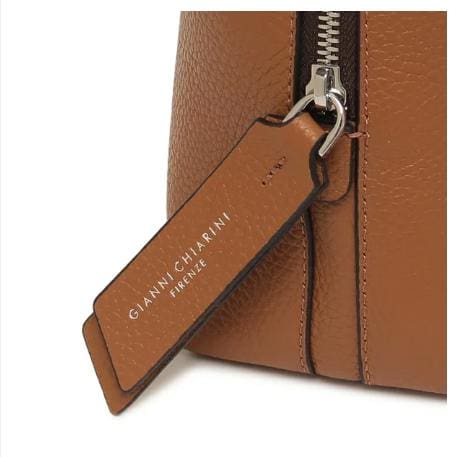 Nahaufnahme der braunen Ledertasche von GIANNI CHIARINI. Es hat einen Metallreißverschluss und ein Lederetikett mit der Aufschrift "GIANNI CHIARINI FIRENZE" in Weiß. Er wird in Italien hergestellt und strahlt zeitlose italienische Eleganz aus.
