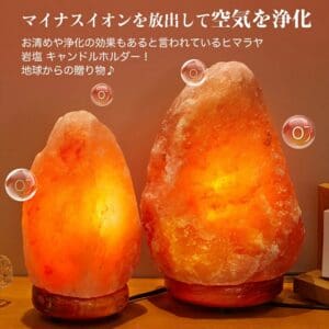 以下は、貴社の製品データを用いて修正した文章です。「2つの輝く 天然岩塩ランプ【サイズ：SS】— ほっと落ち着く、やさしい間接照明— が木製のテーブルの上に置かれ、その上に日本語のテキストが記されています。 ランプは柔らかな間接照明を放ち、温かみのあるオレンジ色の光を照らし出しています。また、「O-」の記号が描かれた泡のイラストが、その空気清浄効果を強調しています。.